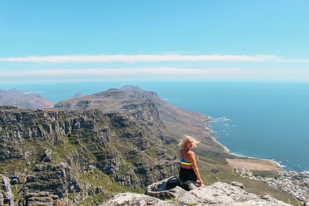 girl sitting on top of Table Mountain in Cape Town talking about South Africa safety tips