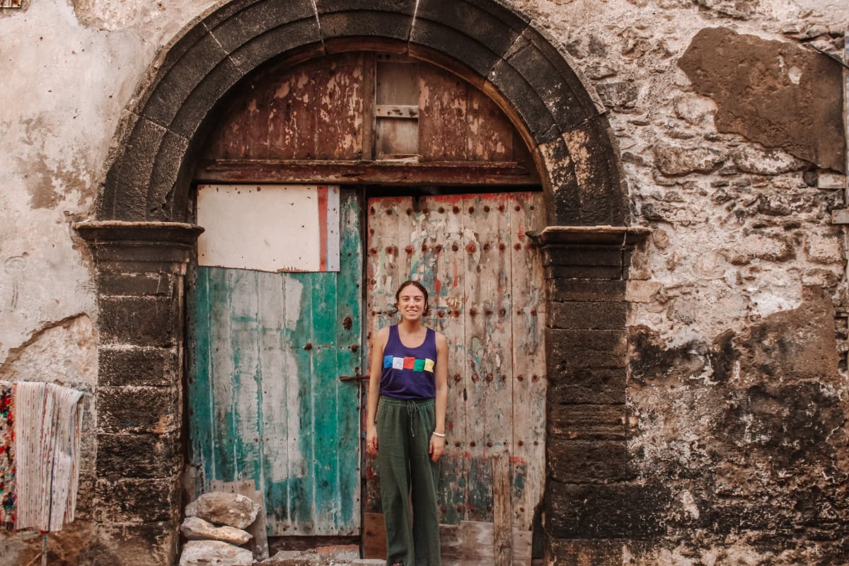 girl standing in front of a colourful door in Essaouira, Morocco