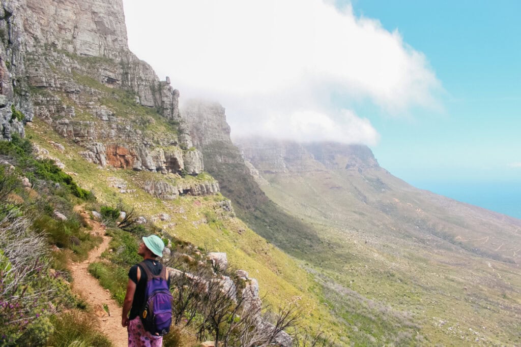 man standing on a mountain in Cape Town wondering how do you say merry christmas in South Africa